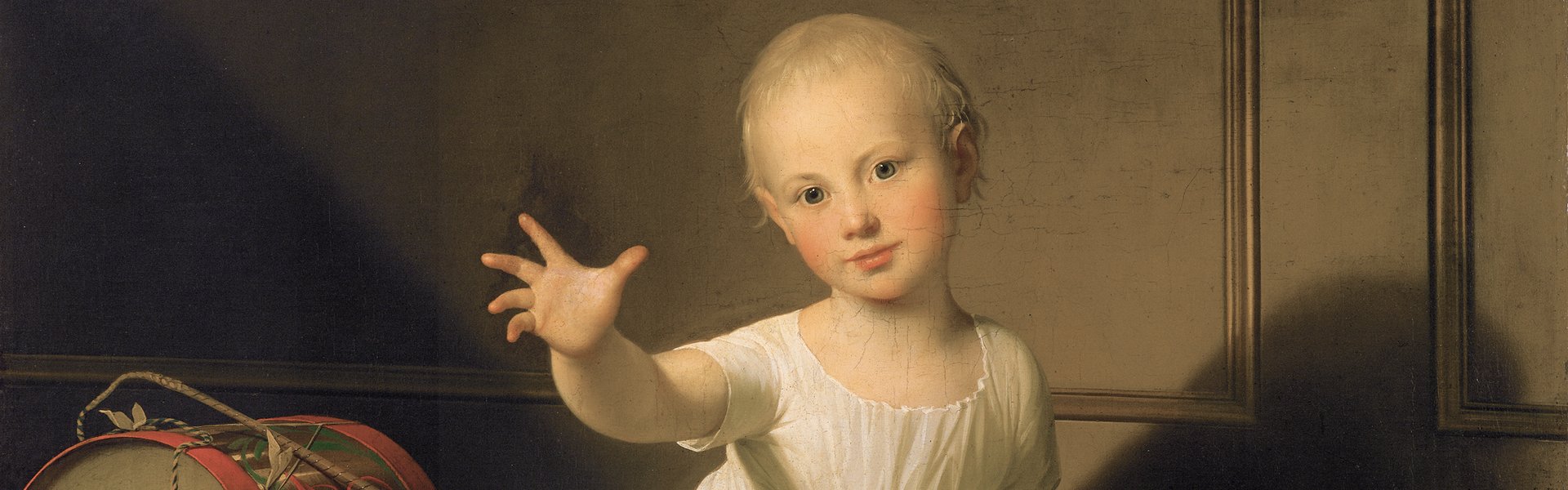 Das Gemälde „Herzog Friedrich Emil August von Schleswig-Holstein-Sonderborg-Augustenburg, gen. Prinz von Noer“ von Jens Juel zeigt einen kleinen Jungen. Er trägt ein weißes Gewand und streckt seine Hand den Betrachtenden entgegen. Neben ihm befindet sich Spielzeug, eine Trommel und ein Holzpferd.. 