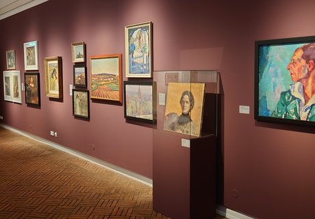 Es ist ein Raum zu sehen, in dem mehrere Bilder einer Ausstellung hängen.