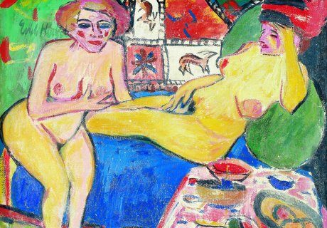 Zwei nackte Frauen sitzen und liegen auf einem Sofa. Im Hintergrund ist ein Teppich mit Tieren an der Wand. Vorne steht ein Tisch mit Früchten.