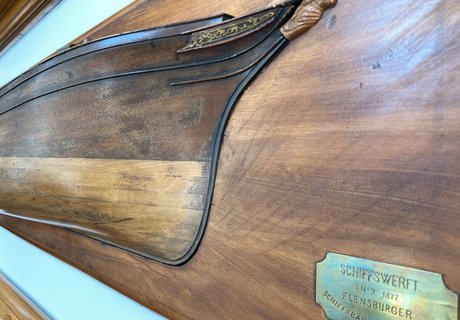 n einer Wand hängt ein Halbschiff der FSG. Es ist eine Detailaufnahme.