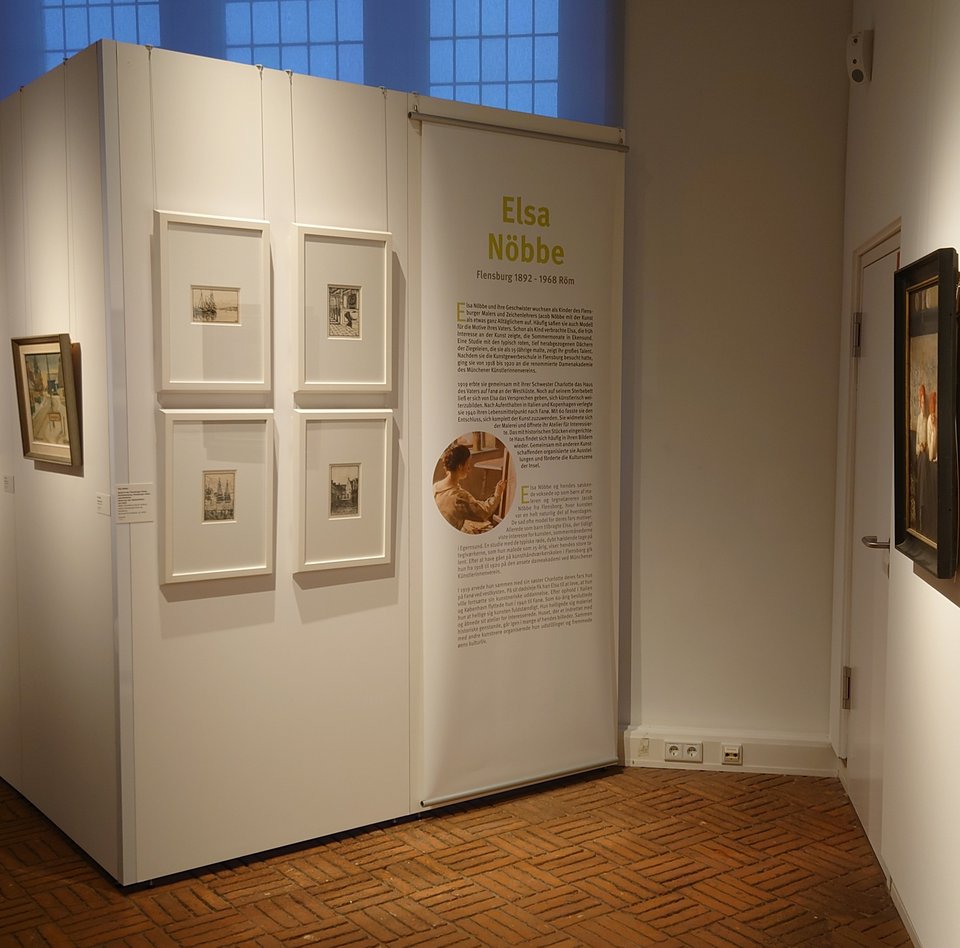 Es ist ein Raum zu sehen, in dem mehrere Bilder einer Ausstellung hängen.