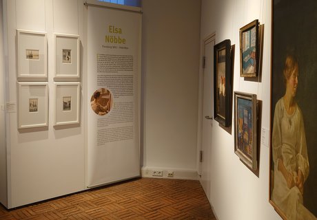 Es ist ein Raum zu sehen, in dem mehrere Bilder einer Ausstellung hängen.