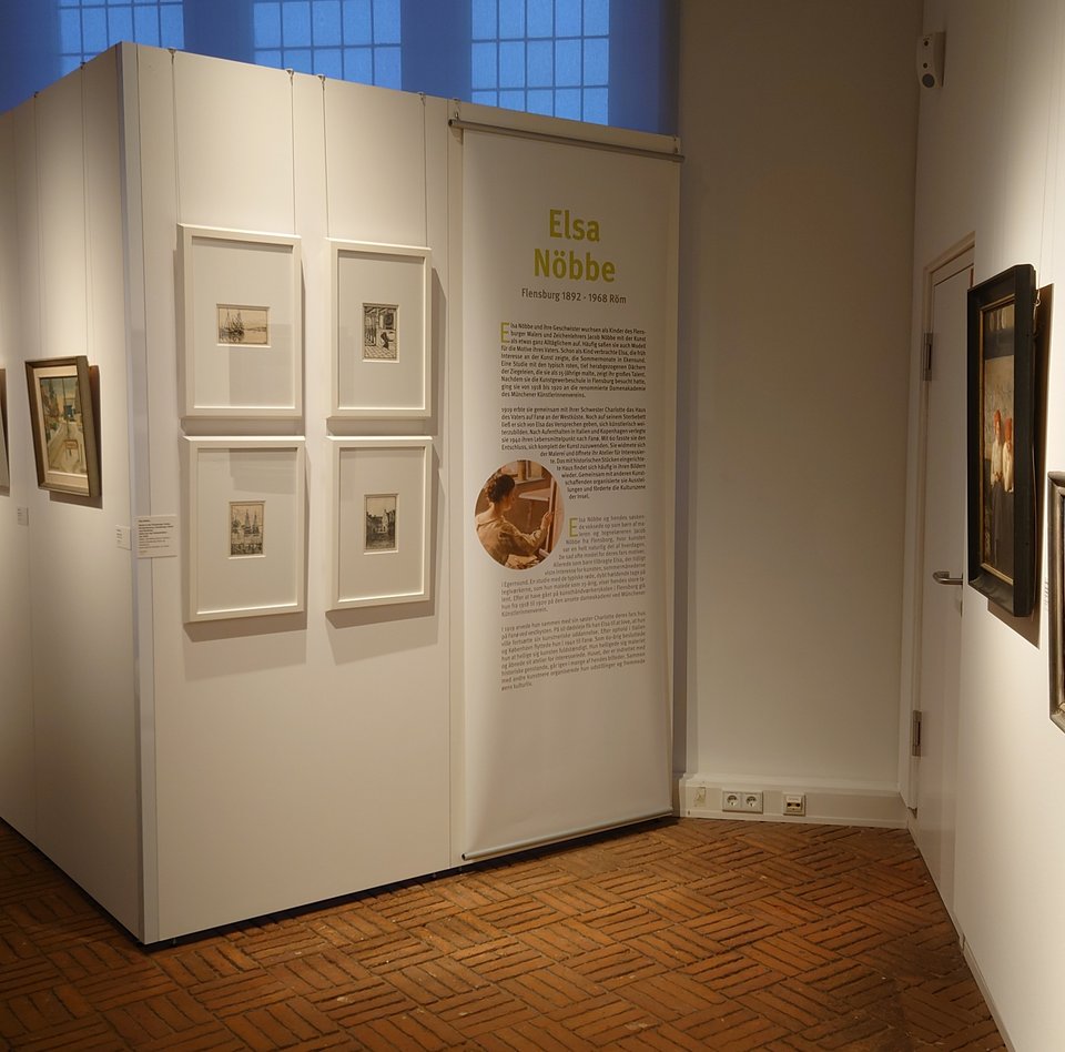 Es ist ein Raum zu sehen, in dem mehrere Bilder einer Ausstellung hängen.