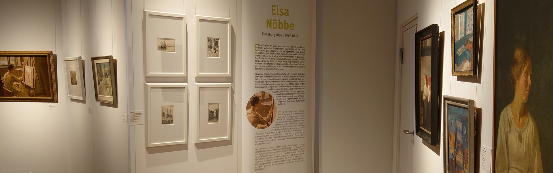 Es ist ein Raum zu sehen, in dem mehrere Bilder einer Ausstellung hängen.