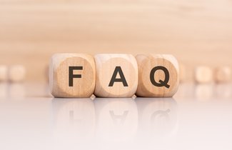 Detailaufnahme von drei Holzwürfel, auf denen die Buchstaben F, A und Q stehen. Der helle Hintergrund ist verschwommen. Dort können weitere Würfel erahnt werden.